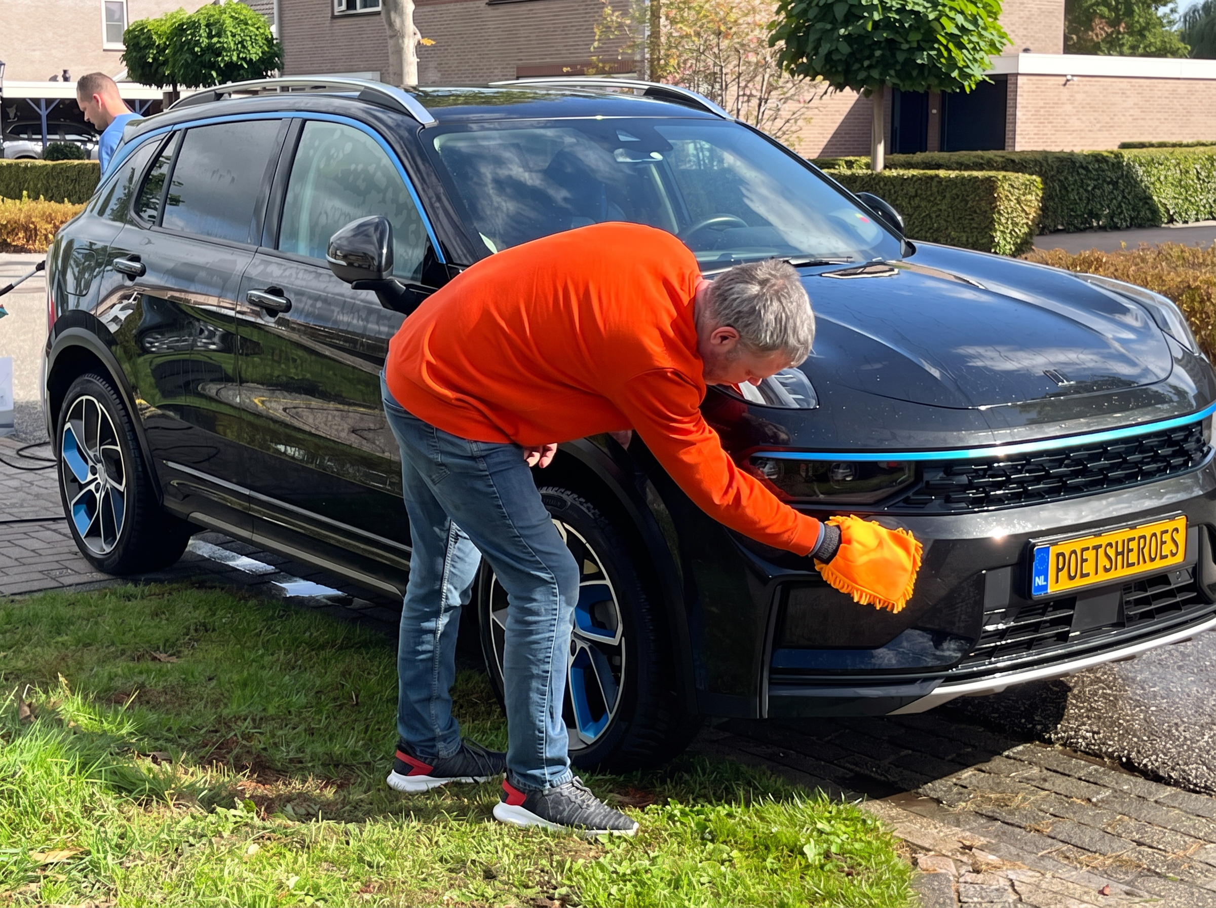 Een PoetsHero poetst de voorkant van een auto op locatie